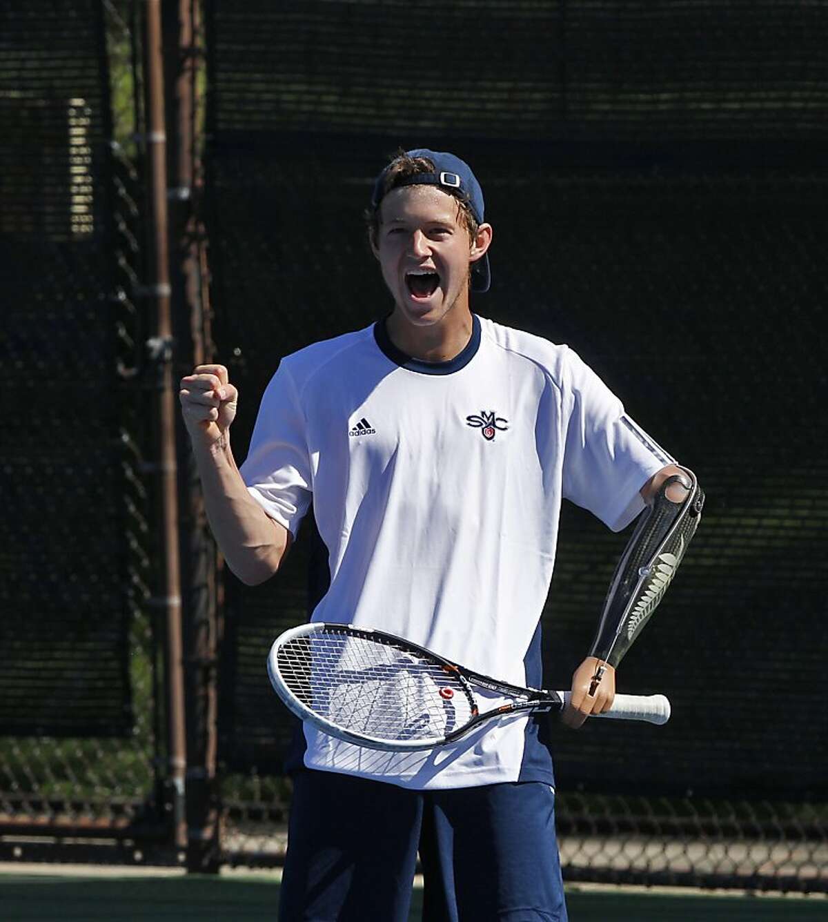 Alex Hunt celebrates a point against his doubles opponent on Wednesday, April 10, 2013. Hunt is a freshman tennis player from New Zealand at St. Mary's College in Moraga, Calif. But that's not what makes him standout, he's playing Div. I tennis with a prosthetic left arm.