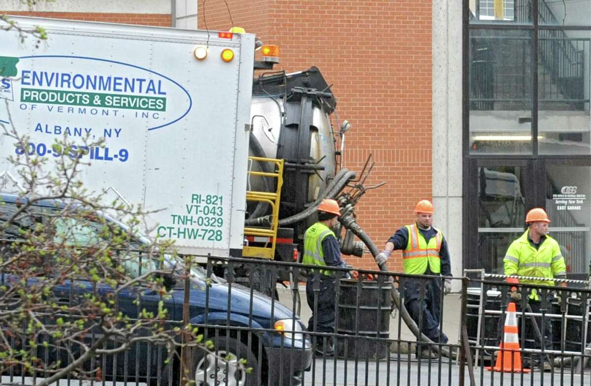 Crews work on a manhole where reports of an underground fire caused the cover to blow near the parking garage on the corner of Madison Ave. and Eagle St. Tuesday morning, April 16, 2013, in Albany, N.Y. (Lori Van Buren / Times Union)