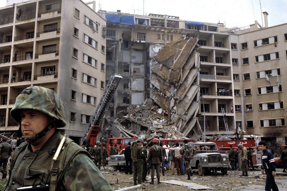 An American Marine Second Lieutenant stands with his back to rescue workers swarming the ruins of the American embassy after a suicide bomber attacked killing 63, including 17 Americans among them CIA station chief Robert Ames, Beirut, April 18, 1983. The US Marines were there as part of the failed Multinational Force peacekeeping intervention in the Lebanese Civil War. Photo: Francoise De Mulder, Roger Viollet/Getty Images / Francoise De Mulder/Roger Viollet