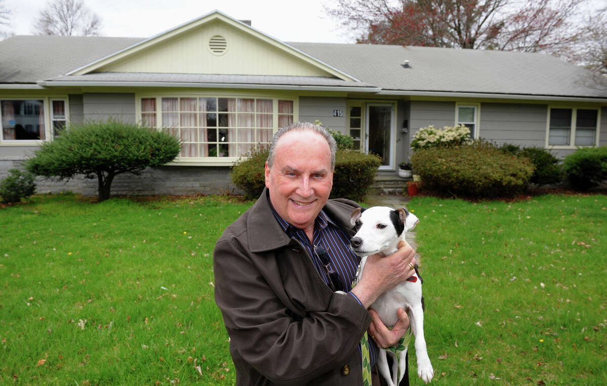 Steven Gaynes stands with his dog Patches out in front of his home on Brooklawn Avenue in Fairfield, Conn. on Thursday April 18, 2013. He has been struggling to sell his home because of issues from the inspections, such as the need for a new roof.