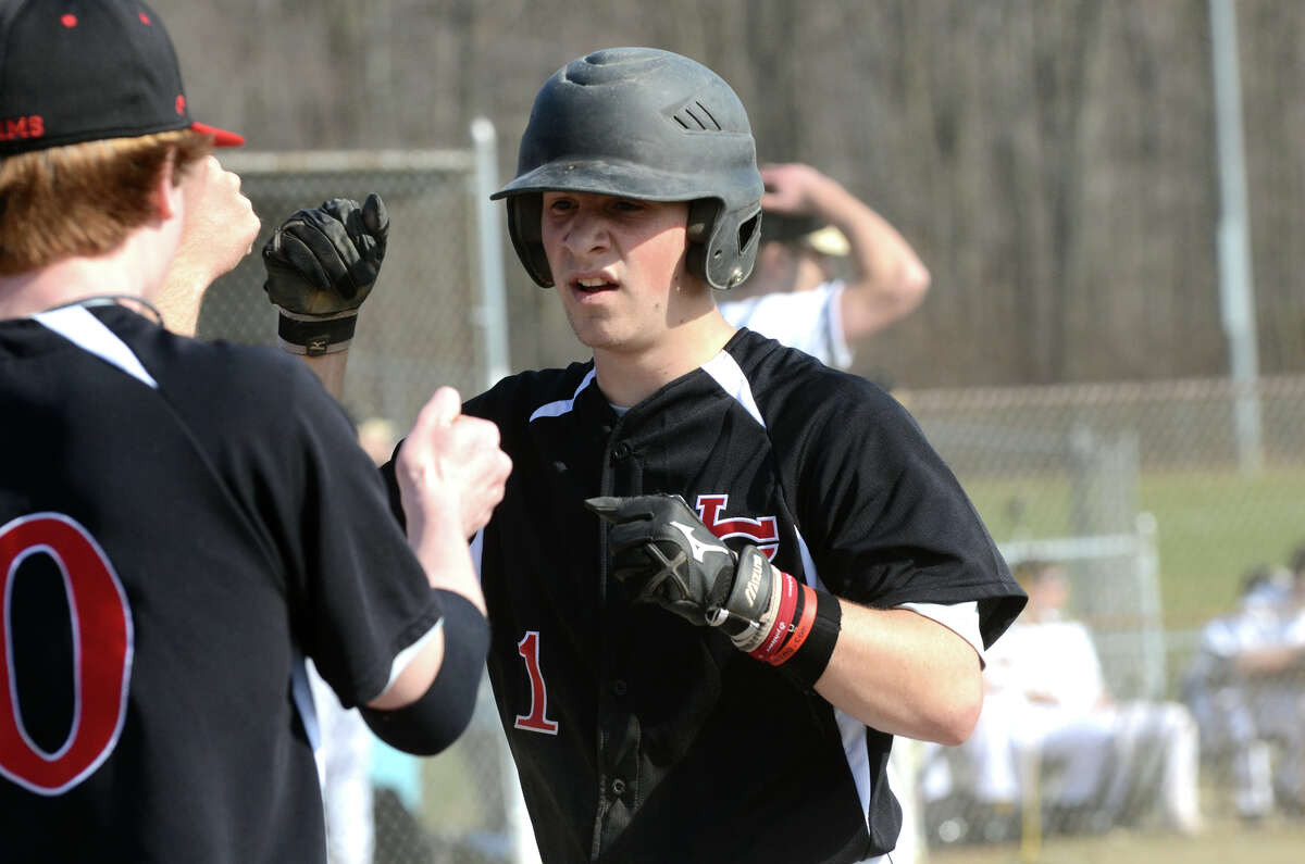 New Canaan's Casey Ouellette (1) is greeted home by teammates during a game earlier this season.