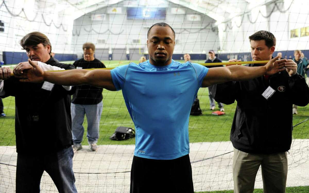 UConn defensive end Trevardo Williams, right, has his arm measured by Panthers scout Robert Haines, left, and 49ers Scout Chip Flanagan, right, during pro day in Storrs, Conn., Wednesday, March 27, 2013. (AP Photo/Jessica Hill)