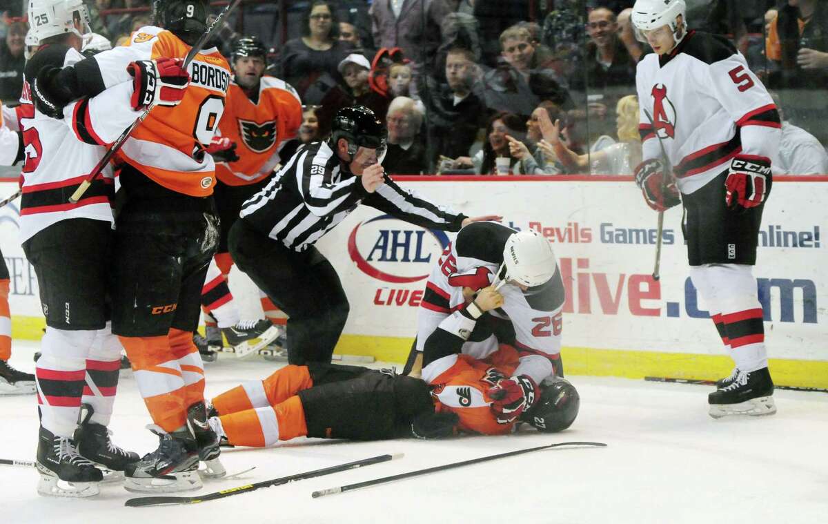 Albany Devils? Mike Hoeffel, center, is removed from the top of Garret Roe of the Adirondack Phantoms, Sunday evening April 21, 2013, after the pair spared in a second period tangle at the Times Union Center. (Will Waldron/Times Union)
