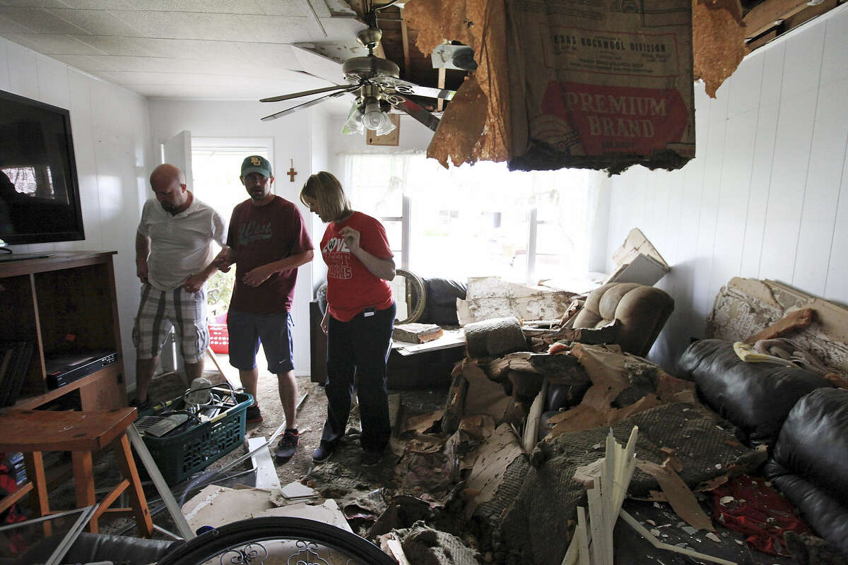 Scott Tacker (second from left) and wife Jennifer get help from her brother Will Matus as they retrieve belongings from their damaged West home.