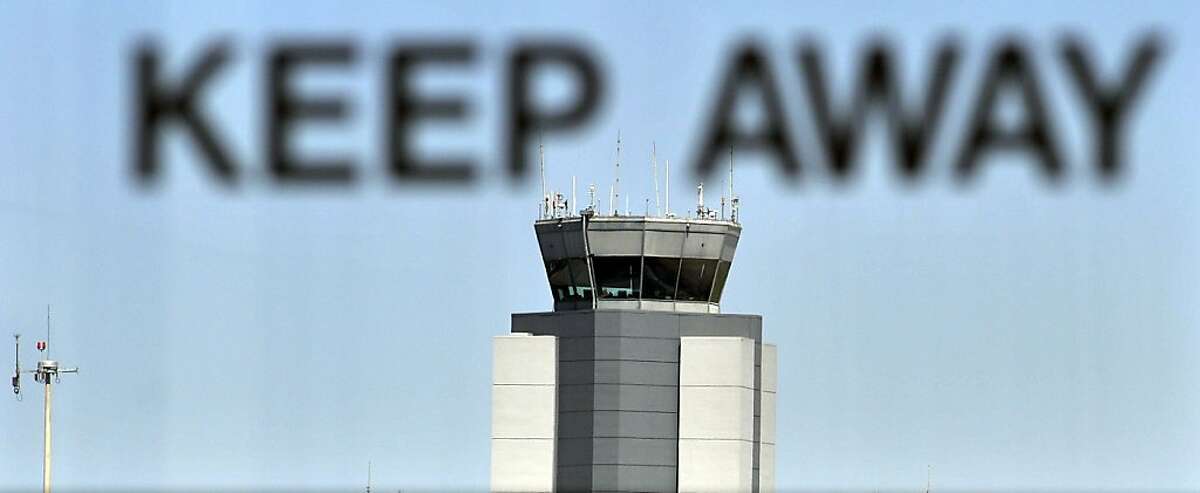 The control tower at San Francisco International Airport is seen through lettering on an emergency door on April 22, 2013, in San Francisco. Federal budget cuts resulted in heavy delays for flights coming from the East Coast.