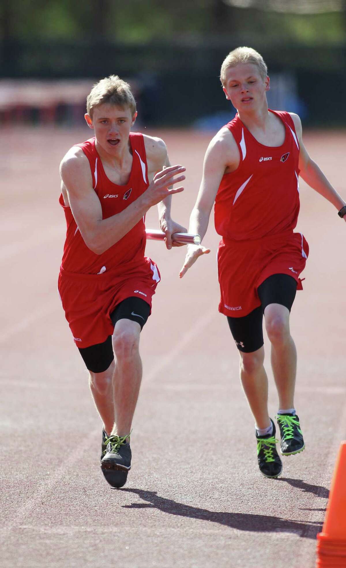 Mark Jaronbach takes the baton from teammate John Sulich for Greenwich High School in the boys 4x800 relay race in Greenwich, Conn. on Monday, April 22, 2013. Greenwich, which hosted the event, took second place in this race.