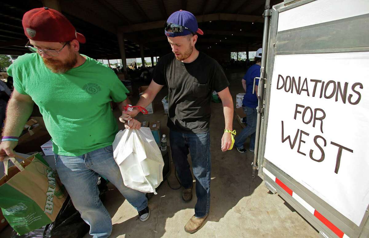 Volunteers unload goods donated for victims on Monday in West.