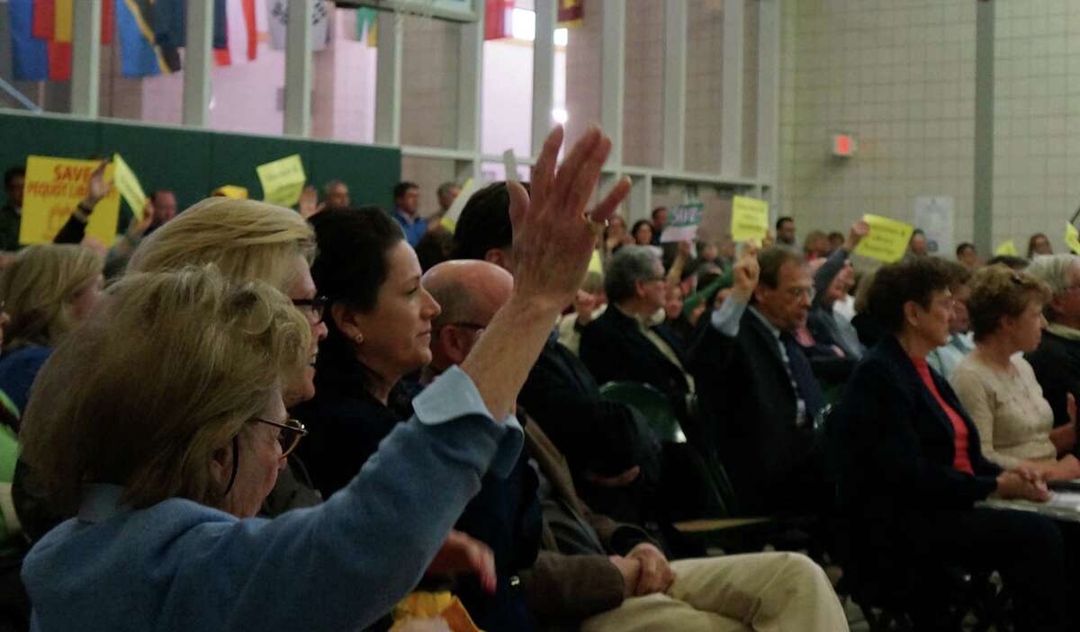 Waving signs and raising hands, a large crowd at Monday's Representative Town Meeting showed support for restoring $350,000 for the Pequot Library to the proposed 2013-14 town budget. FAIRFIELD CITIZEN, CT 4/22/13