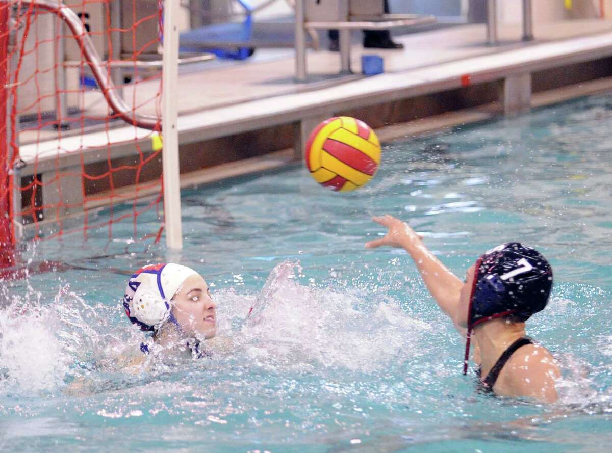 At right, Daniela Screnci of Greenwich High School shoots and scores past Staples goalie Amelia Green during water polo match between Staples High School and Greenwich High School at Greenwich, Tuesday, April 23, 2013.