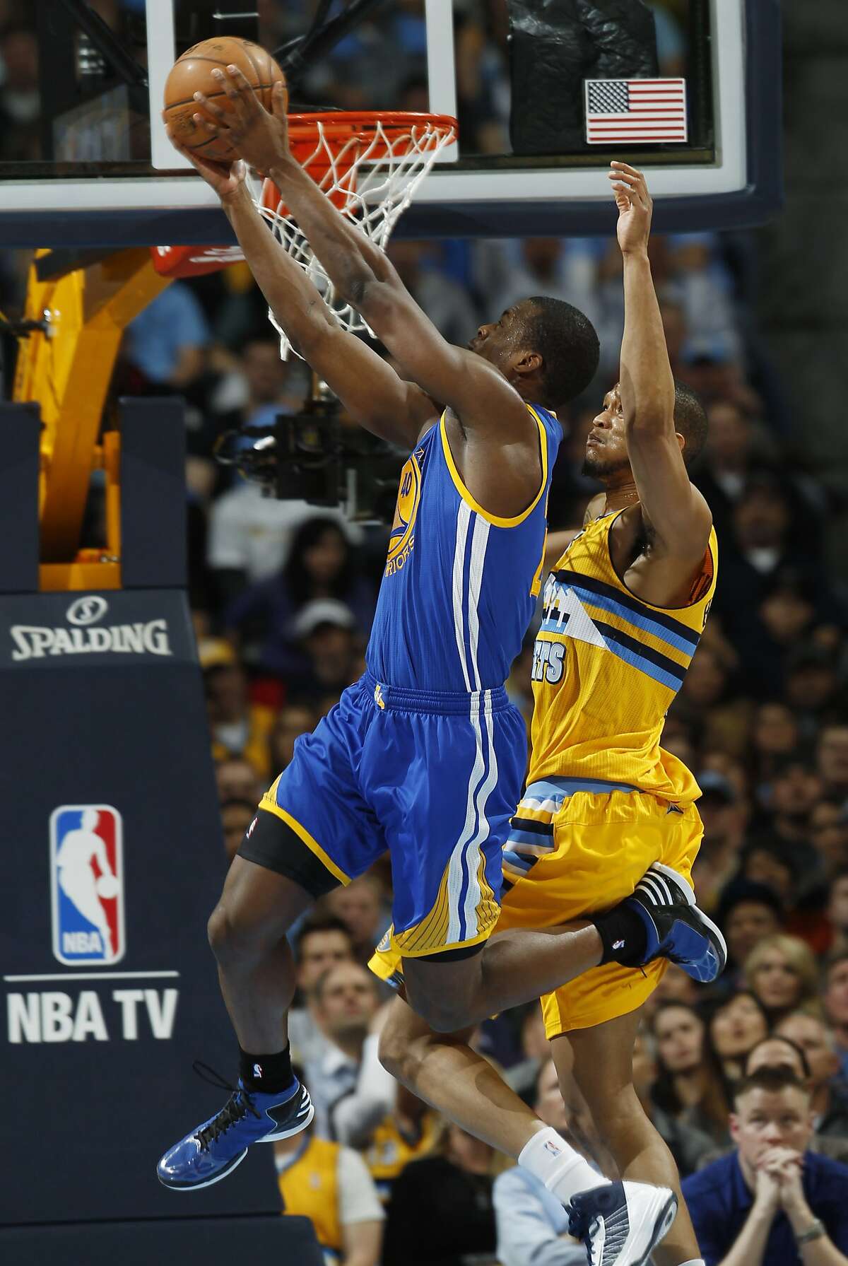 Golden State Warriors forward Harrison Barnes, front, goes up for a reverse dunk past Denver Nuggets forward Anthony Randolph in the fourth quarter of the Warriors' 131-117 victory in Game 2 of the teams' NBA first-round playoff series in Denver on Tuesday, April 23, 2013. (AP Photo/David Zalubowski)