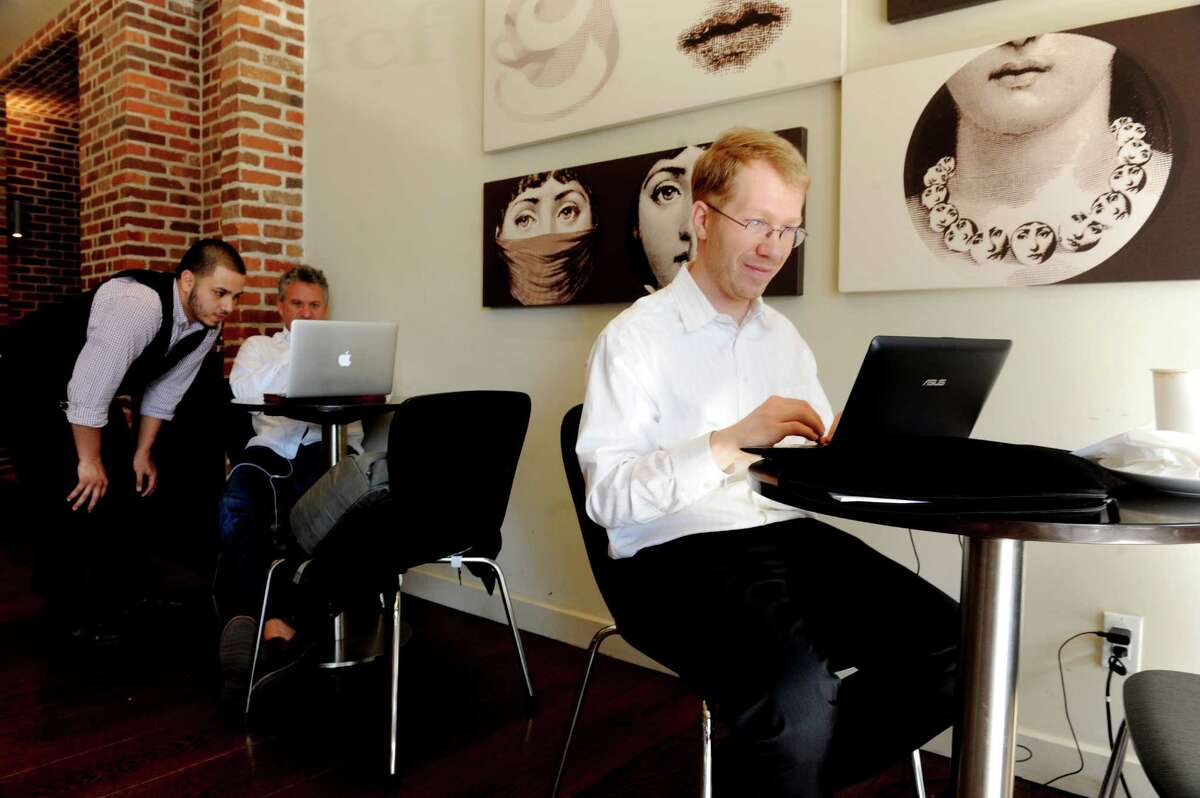 Tyson Maly, right, of Stamford, works at his laptop at CFCF Roastery and Cafe at 118 Greenwich Ave., in Greenwich, Conn., Wednesday, April 24, 2013.