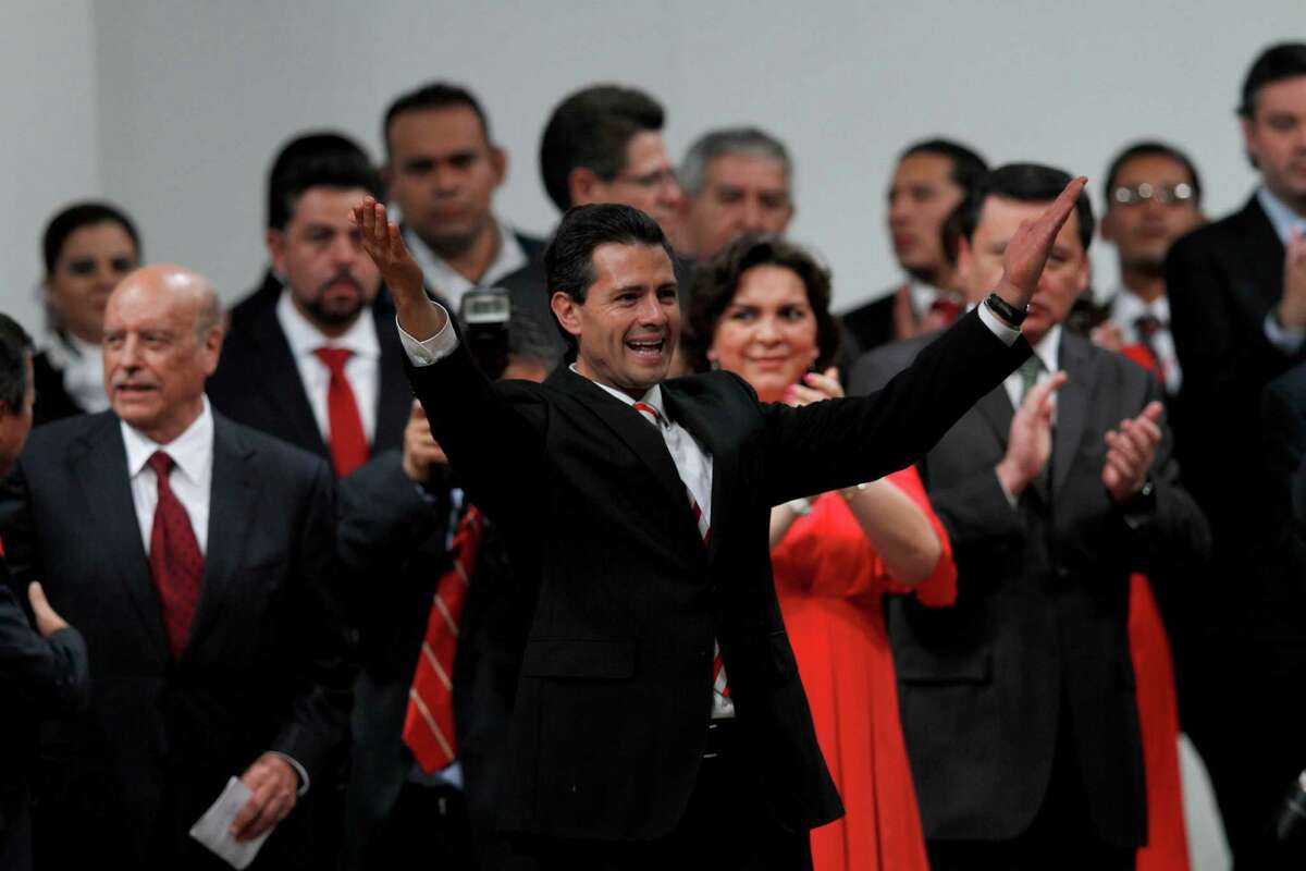 Mexico's President Enrique Pena Nieto, front, waves during a national convention of the Institutional Revolutionary Party (PRI), in Mexico City, Sunday, March 3, 2013. Mexico's ruling party changed on Sunday its platform to allow a reform that could bring private investment into the state-owned oil monopoly, in a country where oil is a source of national pride. (AP Photo/Marco Ugarte)