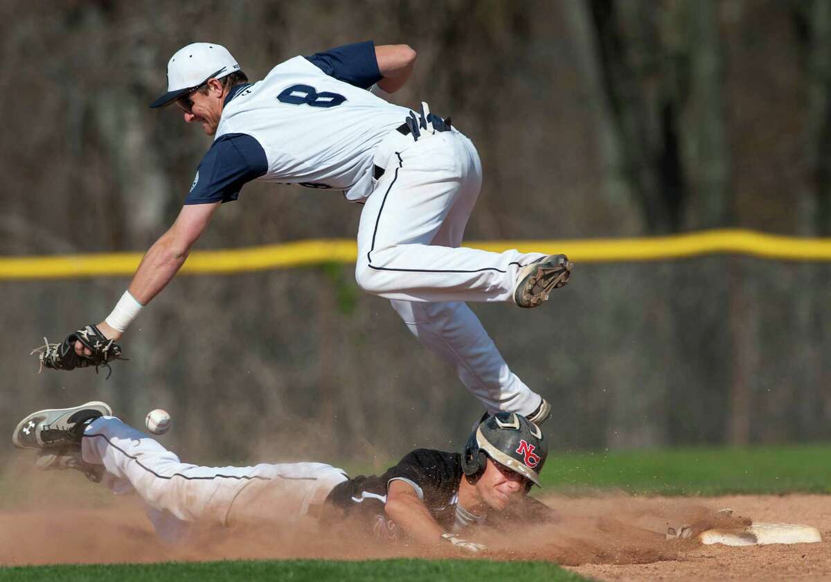 New Canaan high school's Matthew Toth almost gets pick off at second base but Staples high school shortstop Sam Ellinwood can't get a handle on the ball during a baseball game played at Staples high school, Westport, CT on Wednesday April 24th, 2013.