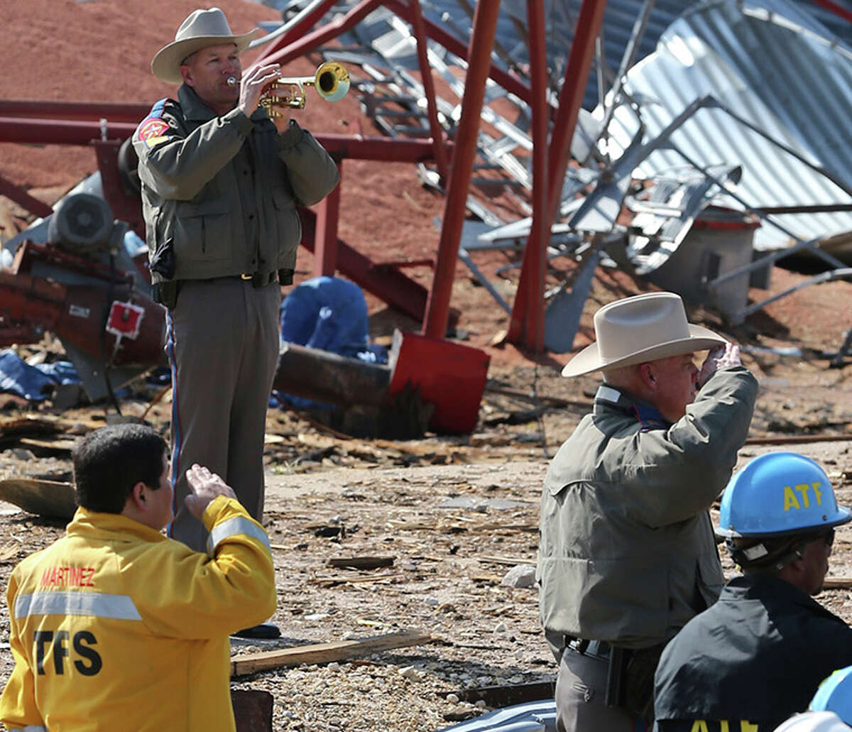 An officer sounds taps at a memorial ceremony at the site of the fire and explosion in West, Texas on April 24 2013.