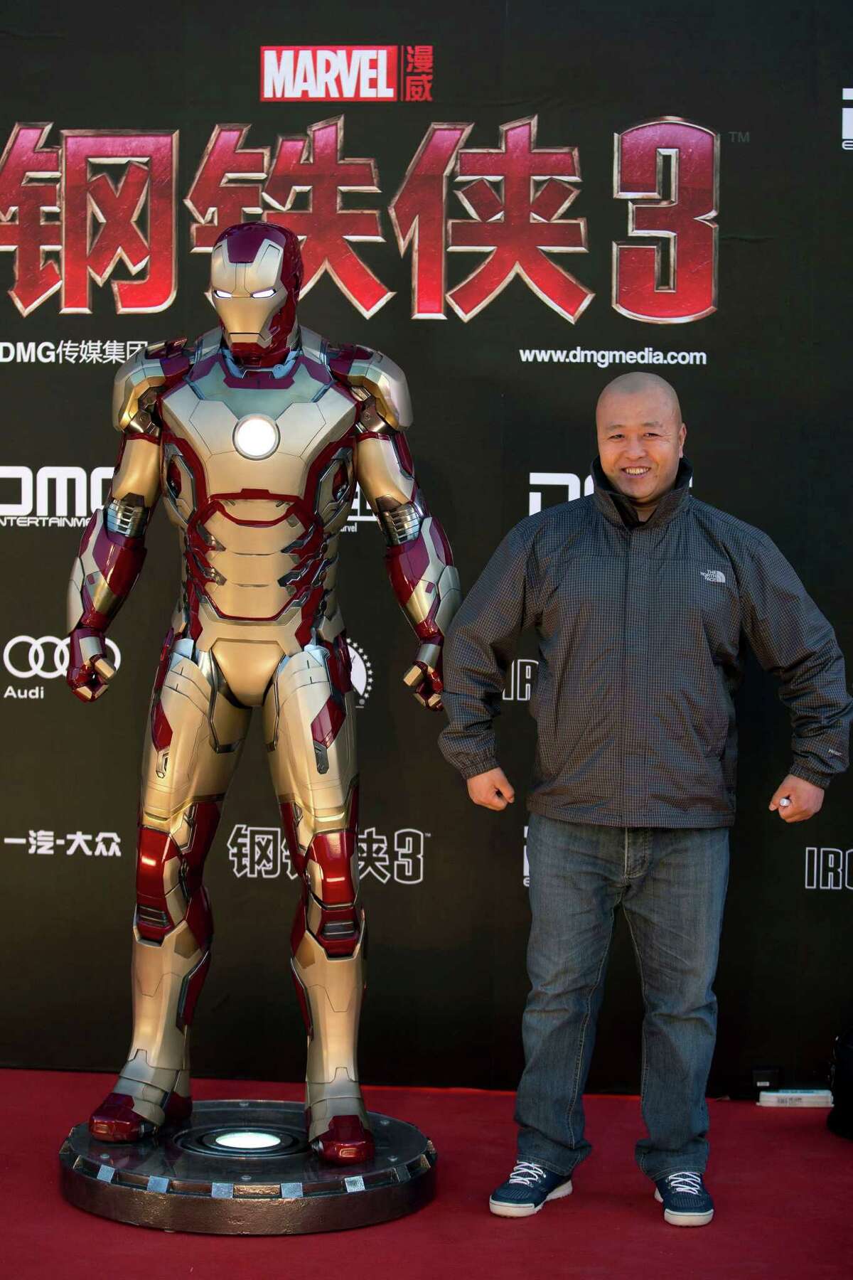 In this photo taken Saturday, April 6, 2013, a Chinese man poses for photographers on stage during a promotional event for the movie "Iron Man 3" before its release in China in early May at the Imperial Ancestral Temple in Beijing's Forbidden City. From demanding changes in plot lines that denigrate the Chinese leadership, to dampening lurid depictions of sex and violence, Beijing is having increasing success in pressuring Hollywood into deleting movie content Beijing finds objectionable. It's even getting American studios to sanction alternative versions of films specially tailored for Chinese audiences, like "Iron Man 3," which debuts in theaters around the world later this week. The Chinese version features local heartthrob Fan Bingbing — absent from the version showing abroad — and lengthy clips of Chinese scenery that local audiences love.(AP Photo/Andy Wong)