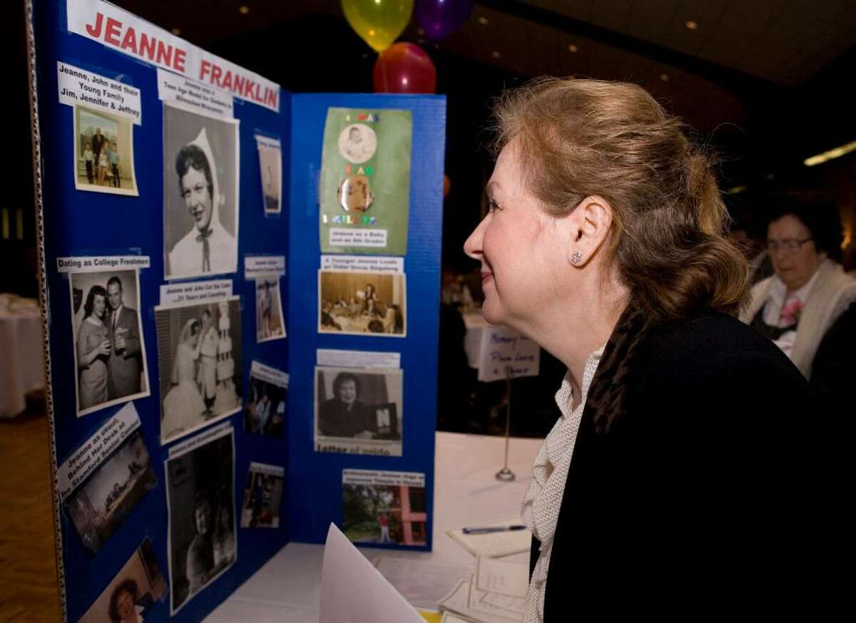 Svetlana Wijayadasa looks at a memory board chronicling the life of Jeanne Franklin, outgoing Stamford Senior Center director, who was being honored at a fundraiser at the Italian Center.