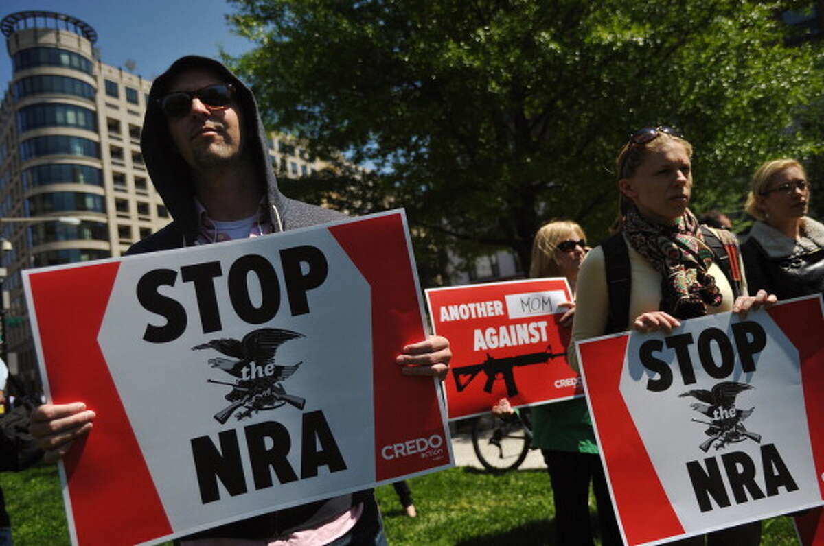 Protesters hold placards during a demonstration calling for tighter gun control on April 25, 2013 in McPherson Square in Washington, DC. The National Rifle Association (NRA) is lobbying against gun reforms laws being debated in the US Congress. AFP PHOTO/Mandel NGAN (Photo credit should read MANDEL NGAN/AFP/Getty Images)