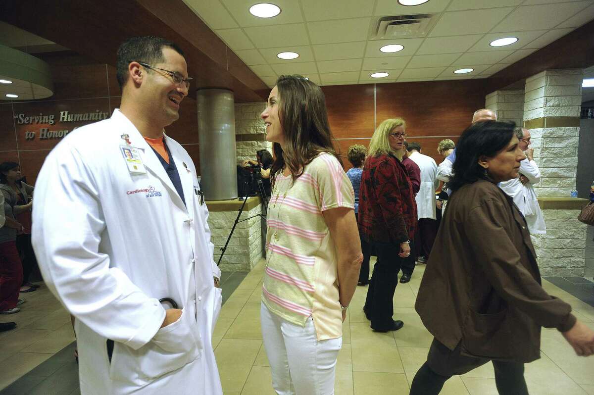 Dr. Jorge Alvarez (left), a cardiologist with the Cardiology Clinic of San Antonio, talks with his wife, Becky, after a ceremony in which he was honored for assisting the wounded after the bombings at the Boston Marathon.