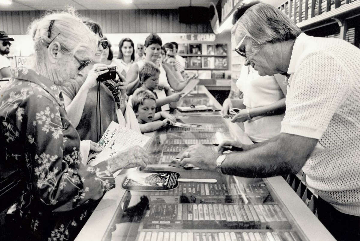 George Jones signs an autograph for Etta Runnels of Vidor at The Record Rack while other fans wait for their turn. Jones was in Beaumont to sign autographs and greet fans. Photo: The Beaumont Enterprise archives.