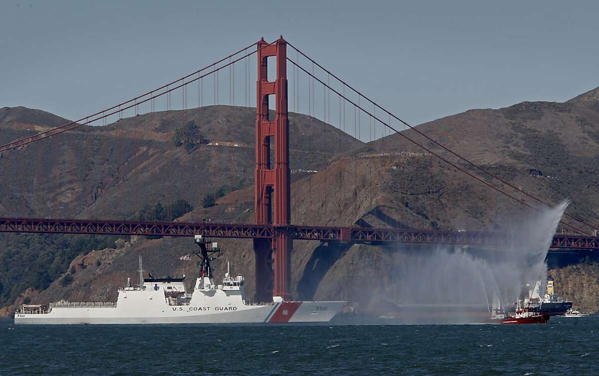 US Coast Guard Cutter Bertholf sails under the Golden Gate Bridge being led by a San Francisco fireboat as Fleetweek 2008 returns to San Francisco, Calif., hundreds gather along the edge of the Bay to watch the festivities on Saturday Oct.11, 2008.