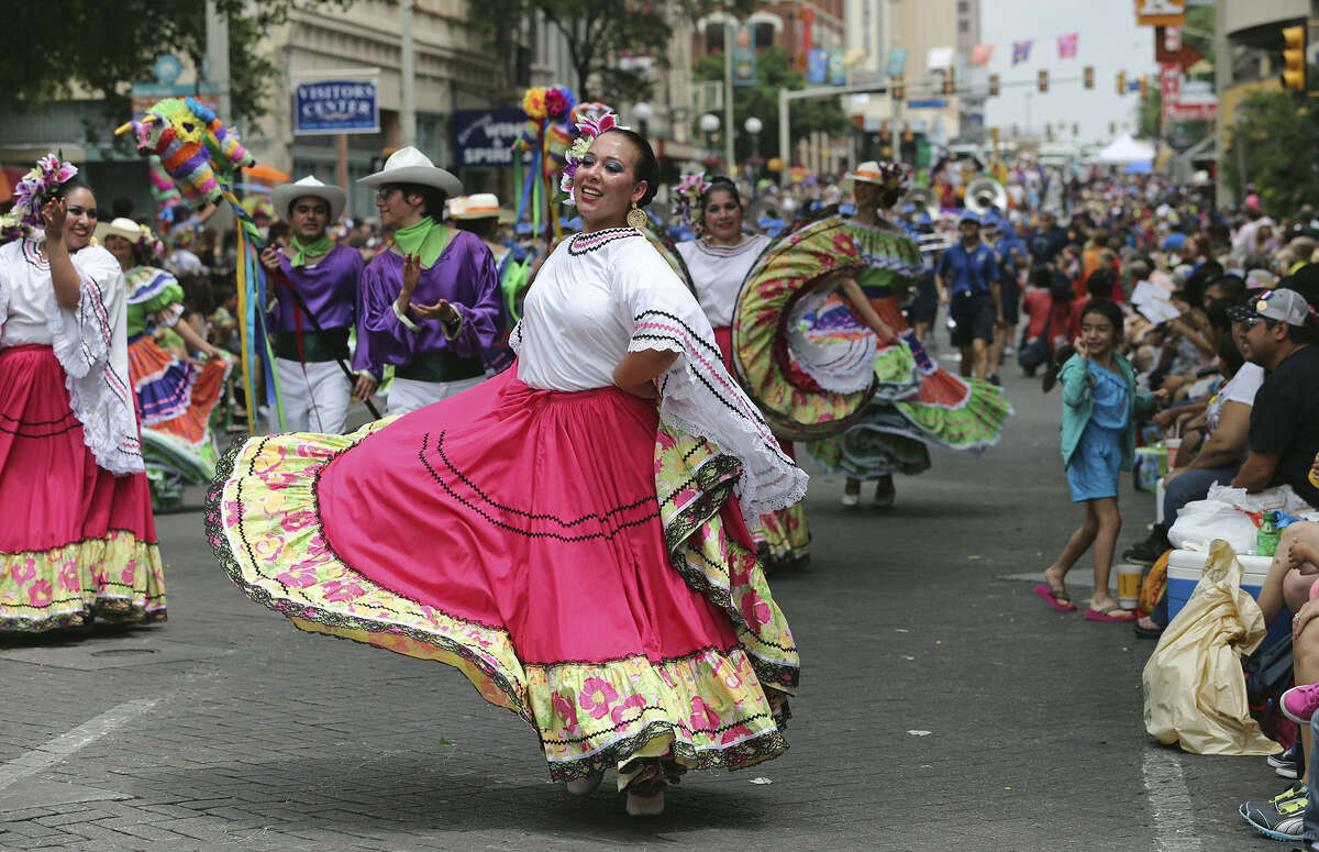 St. Edward's University Ballet Folklorico dancers perform on Commerce Street as the Battle of Flowers Parade makes its way from lower Broadway through downtown.