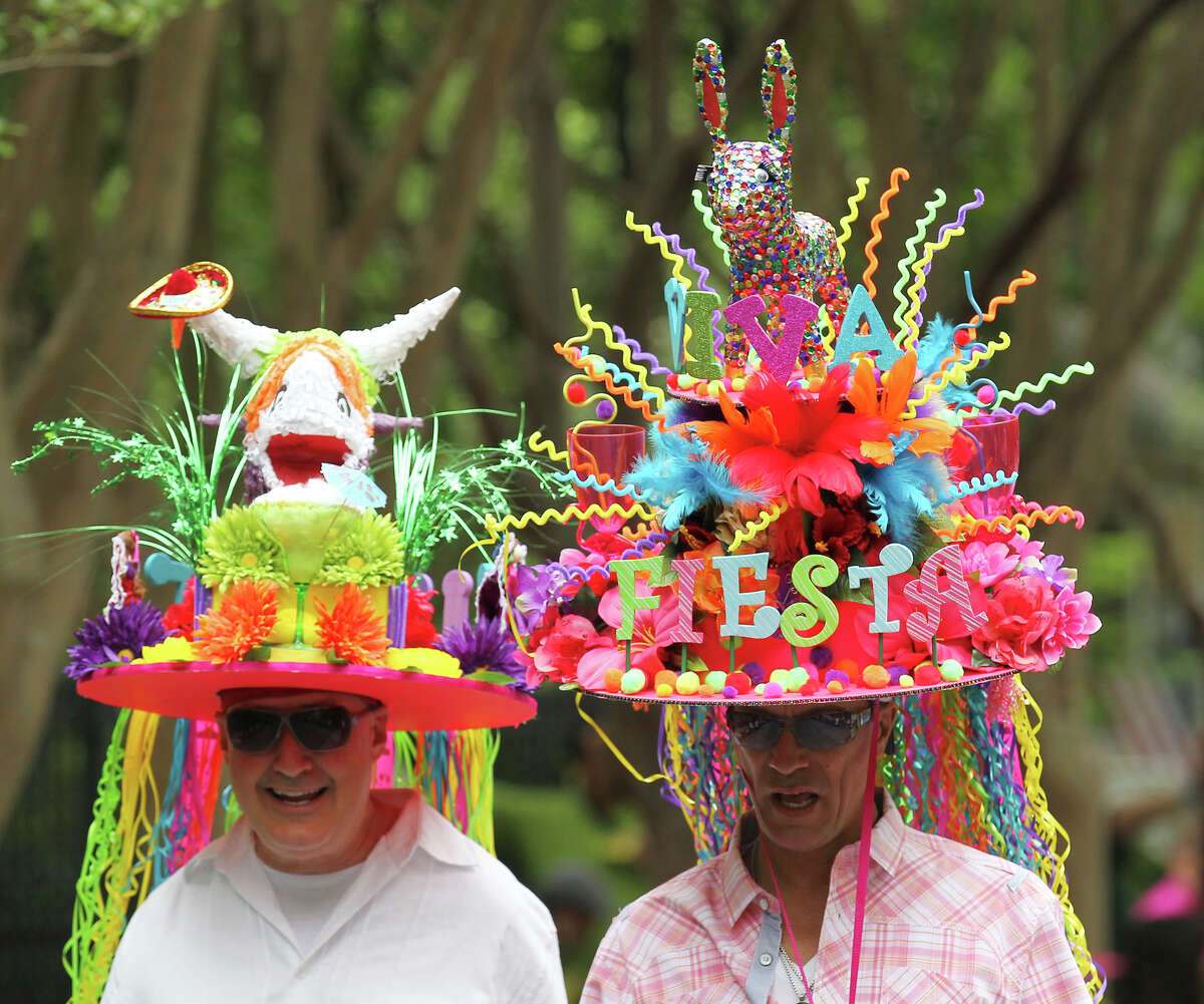Tye Wichert (center) and Guy Pritchard wear festive hats made by Wichert at the King William Fair Parade on Saturday, Apr. 27, 2013. Wichert said he spent about a week making the hats and has created a different one for the past five years.