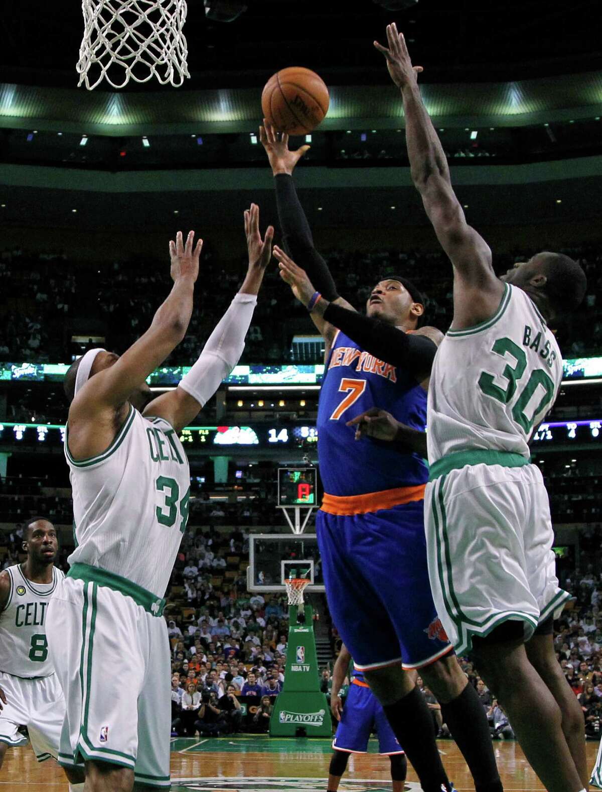 New York Knicks forward Carmelo Anthony (7) shoots against Boston Celtics forwards Paul Pierce (34) and Brandon Bass (30) during the first half in Game 4 of a first-round NBA basketball playoff series in Boston, Sunday, April 28, 2013. (AP Photo/Elise Amendola)