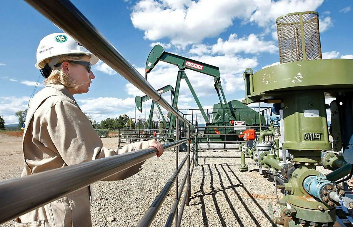 In this Aug. 26, 2009 file photo, Kourtney Hardwick, BP Florida operations manager, looks over a methane gas well site east of Bayfield, Colo.