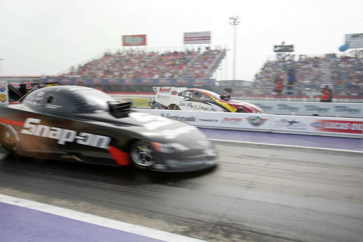 Cruz Pedregon, left, edges Tim Wilkerson in the final round of the Funny Car competition on Sunday.
