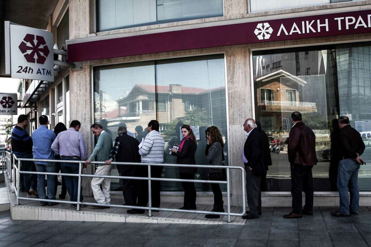 A crowd lines up outside a Laiki Bank branch in Nicosia, Cyprus, March 29, 2013. In Cyprus, as the realization sinks in of how badly the national economy might be ravaged by the combination of capital controls on the flow of money out of the country, the damage and pain are resulting in a rising anger. (Angelos Tzortzinis/The New York Times)