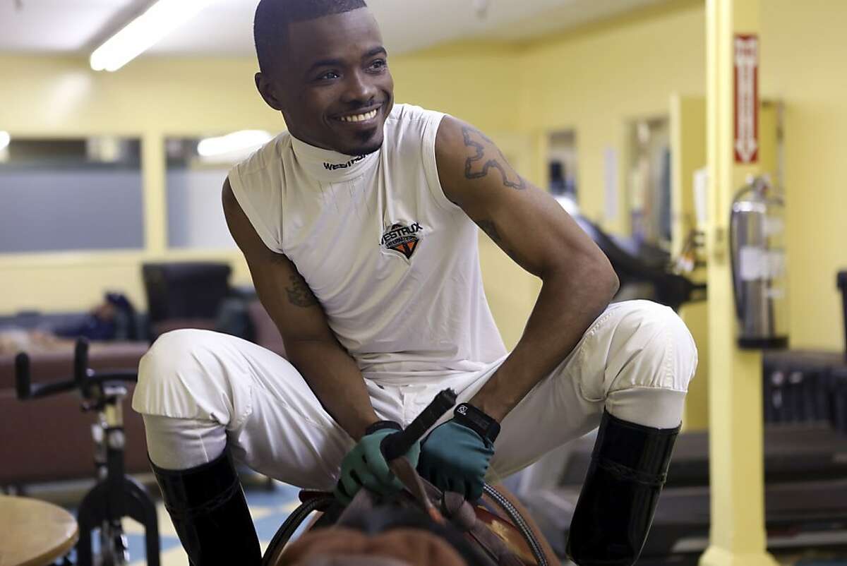 Kevin Krigger, a jockey, adjusts his saddle at Santa Anita Park in Arcadia, Calif., April 20, 2013. Krigger is poised to become the first black jockey to ride in the Kentucky Derby since 2000. (Ann Johansson/The New York Times)