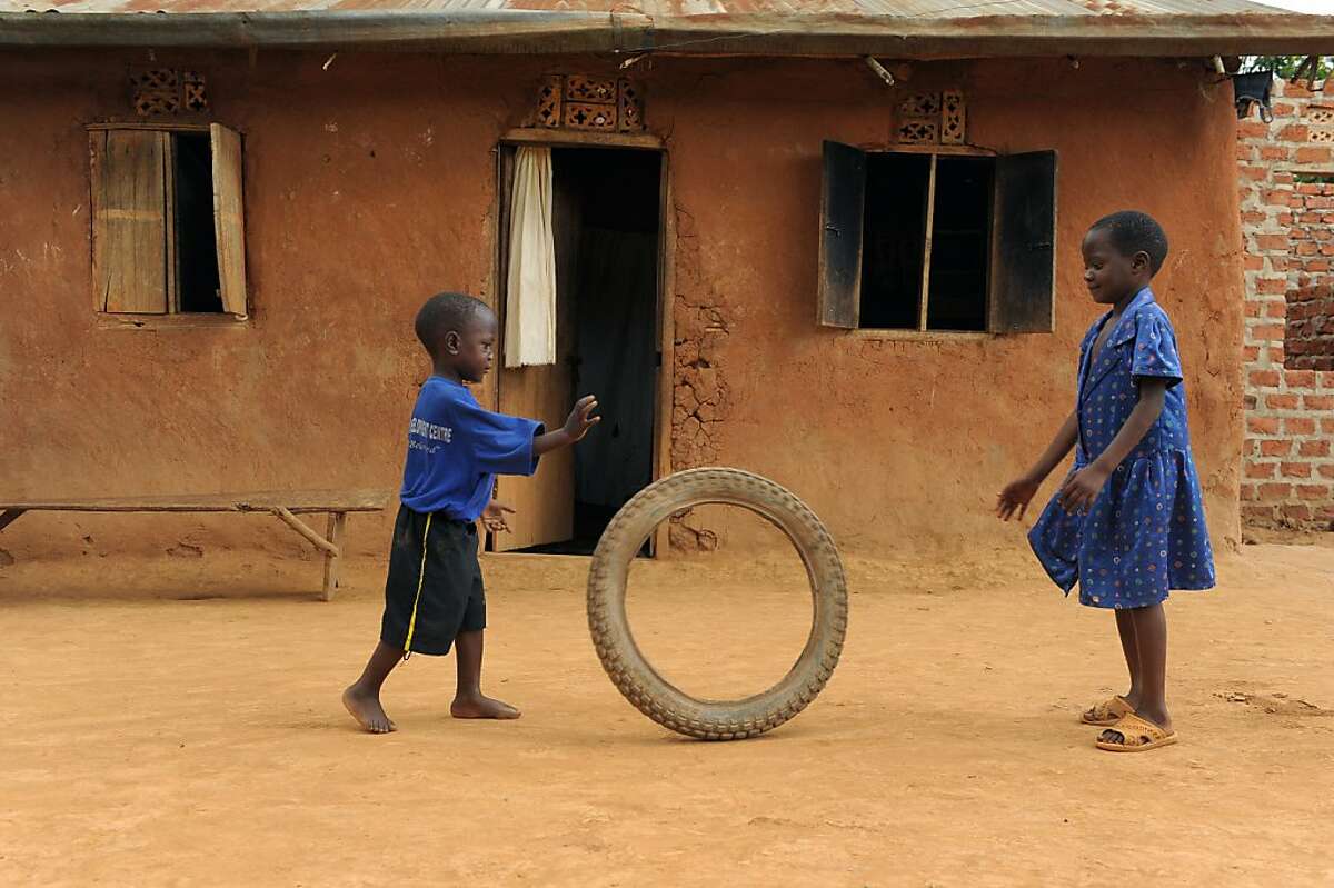 Nicolas, age 4, left, and his sister (name unavailable) play in front of their home in Uganada. Nicholas was 6 months old when his mother abandoned the family. He has been in Compassion's program for 2 years.