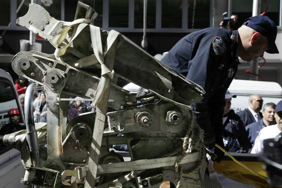 Officials load a plane part that was discovered wedged between an apartment building and a planned mosque into a truck in New York City. Authorities believe the part is from one of the two hijacked airliners that brought down the World Trade Center on Sept. 11, 2001.