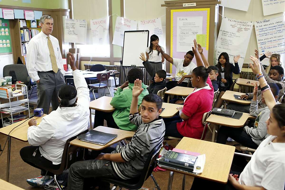 8th grade students raise their hand after being asked if they planned on attending college during a questions and answers session with U.S. Secretary of Education Arne Duncan (far left) during a tour of Everett Middle School on Thursday, May 2, 2013 in San Francisco, Calif.