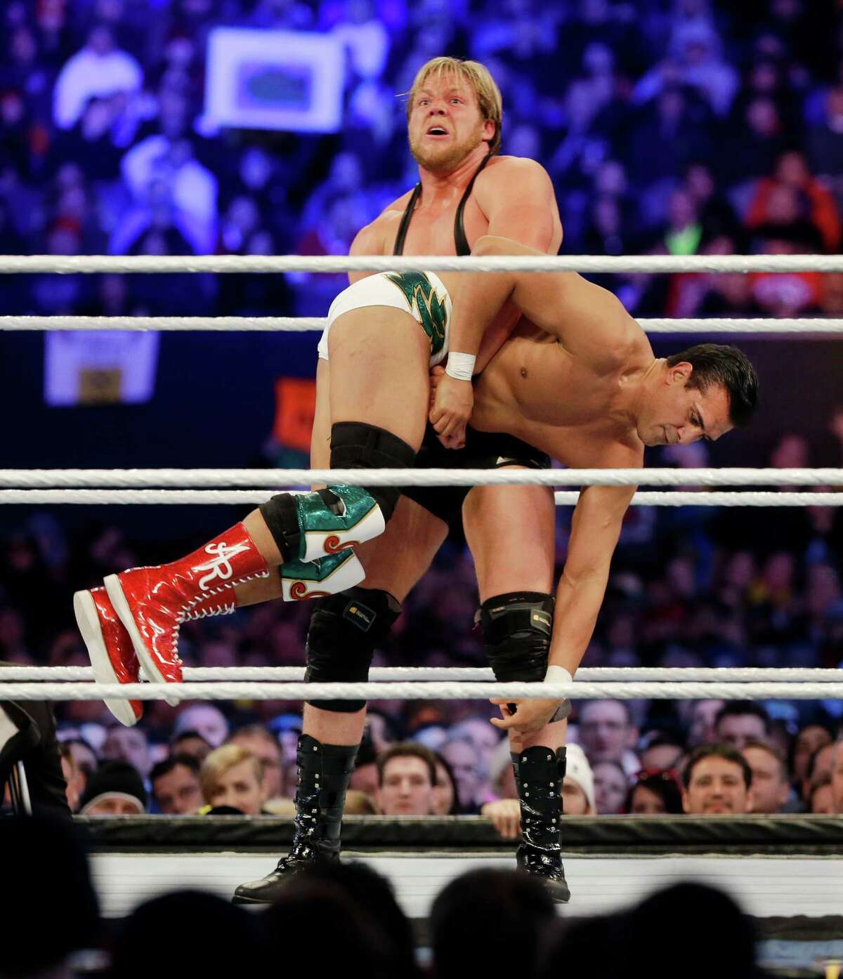 Jacob "Jake" Hager, Jr., known as Jack Swagger, top, lifts Jose Alberto Rodríguez, of Mexico, known as Alberto Del Rio as they wrestle Sunday, April 7, 2013, in East Rutherford, N.J., during the WWE Wrestlemania 29 event. (AP Photo/Mel Evans)