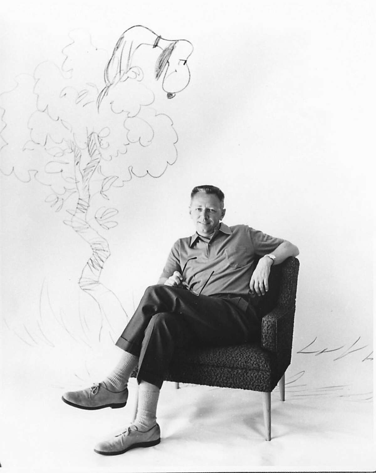 Charles Schulz sitting in a mid-century modern chair and Snoopy in the background as a vulture