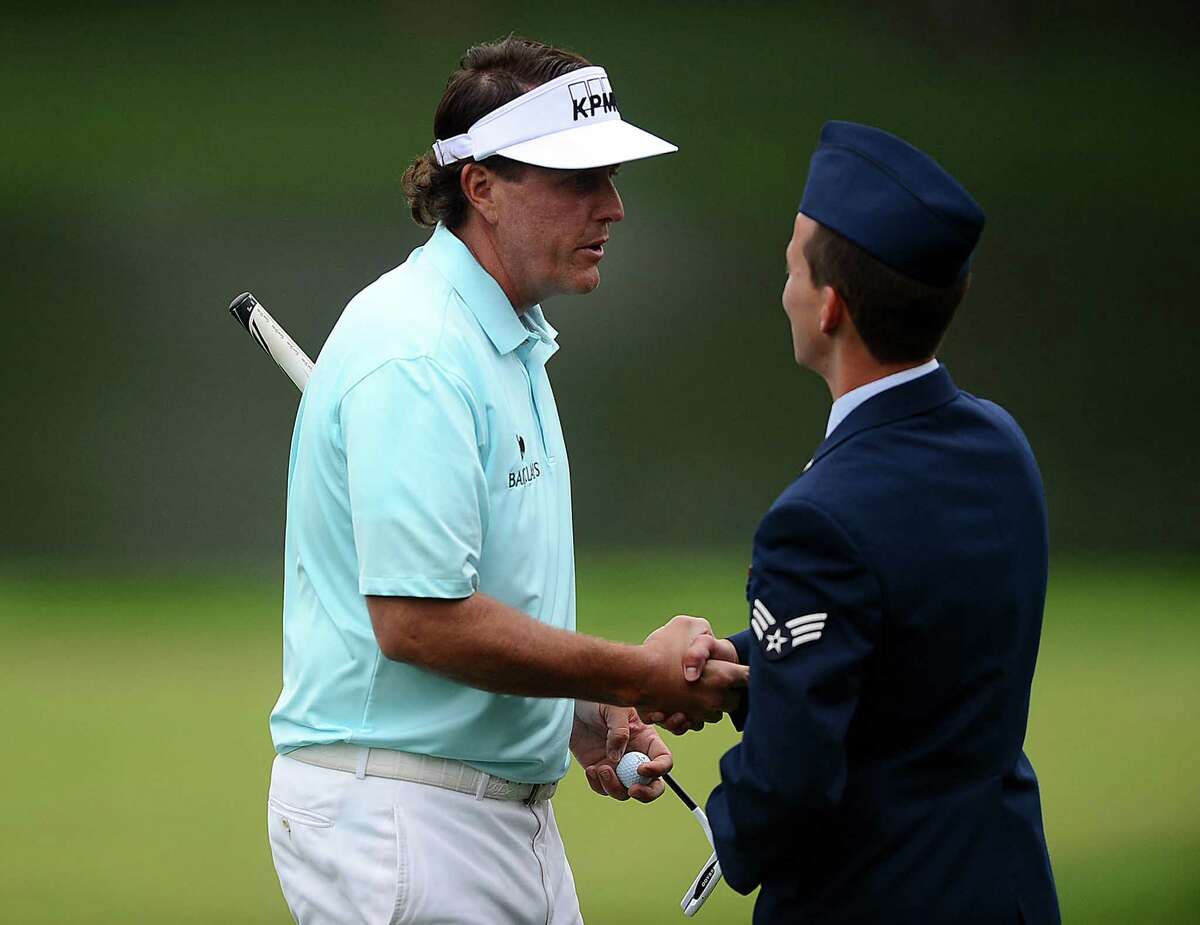 Phil Mickelson shakes hands with USAF senior airman Nathan Horton, who was tending the No. 17 hole.