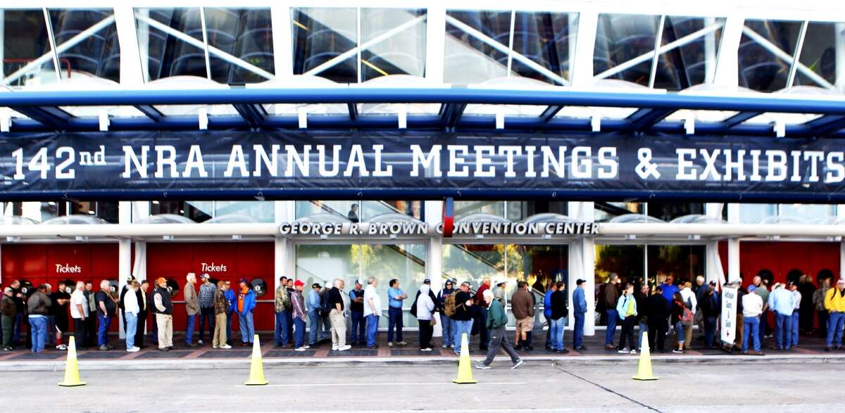 Convention goers line up outside of the George R. Brown Convention Center in Houston, site of the 2013 NRA Convention, Friday, May 3, 2013.