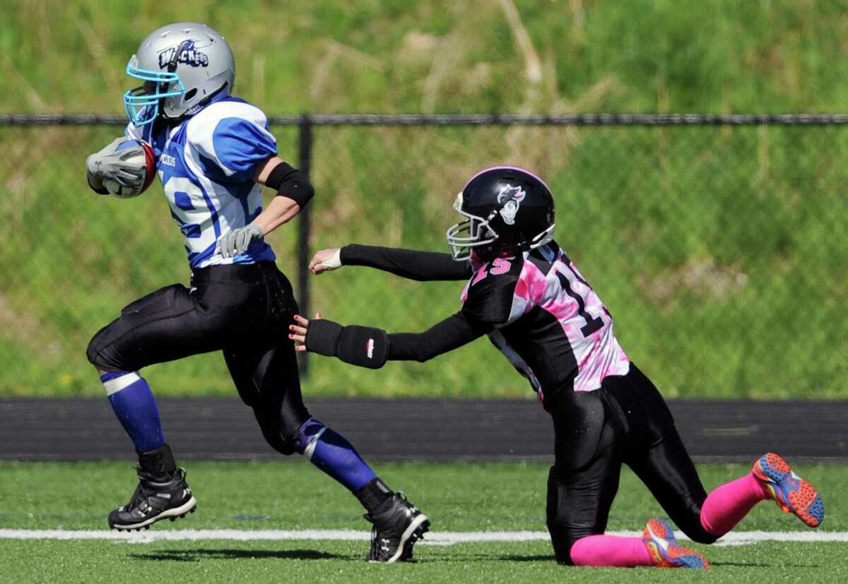 Connecticut's Lauren Manfred, left, runs by New York defender Kim Mills during the New York Knockouts' 14-13 win over the Connecticut Wreckers in the Wreckers' Independent Women's Football League home-opener at Immaculate High School in Danbury, Conn. on Saturday, May 4, 2013.