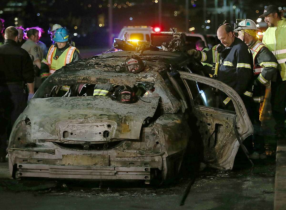 San Mateo County firefighters and California Highway Patrol personnel investigate the scene of a limousine fire on the westbound side of the San Mateo-Hayward Bridge in Foster City, Calif., on Saturday, May 4, 2013. Five people died when they were trapped in the limo that caught fire as they were traveling, and four others and the driver were able to escape, according to the Oakland Tribune-Bay Area News Group. (AP Photo/Oakland Tribune-Bay Area News Group, Jane Tyska)