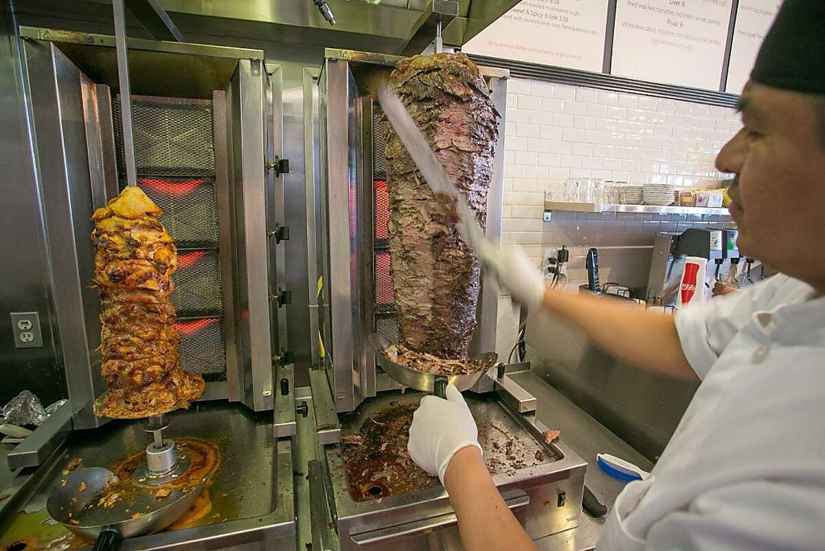 Chef Efrain Toxcon cuts beef for the Gyros Plate at the Hummus Mediterranean Kitchen in San Mateo, Calif., on Thursday, May 2nd, 2013.