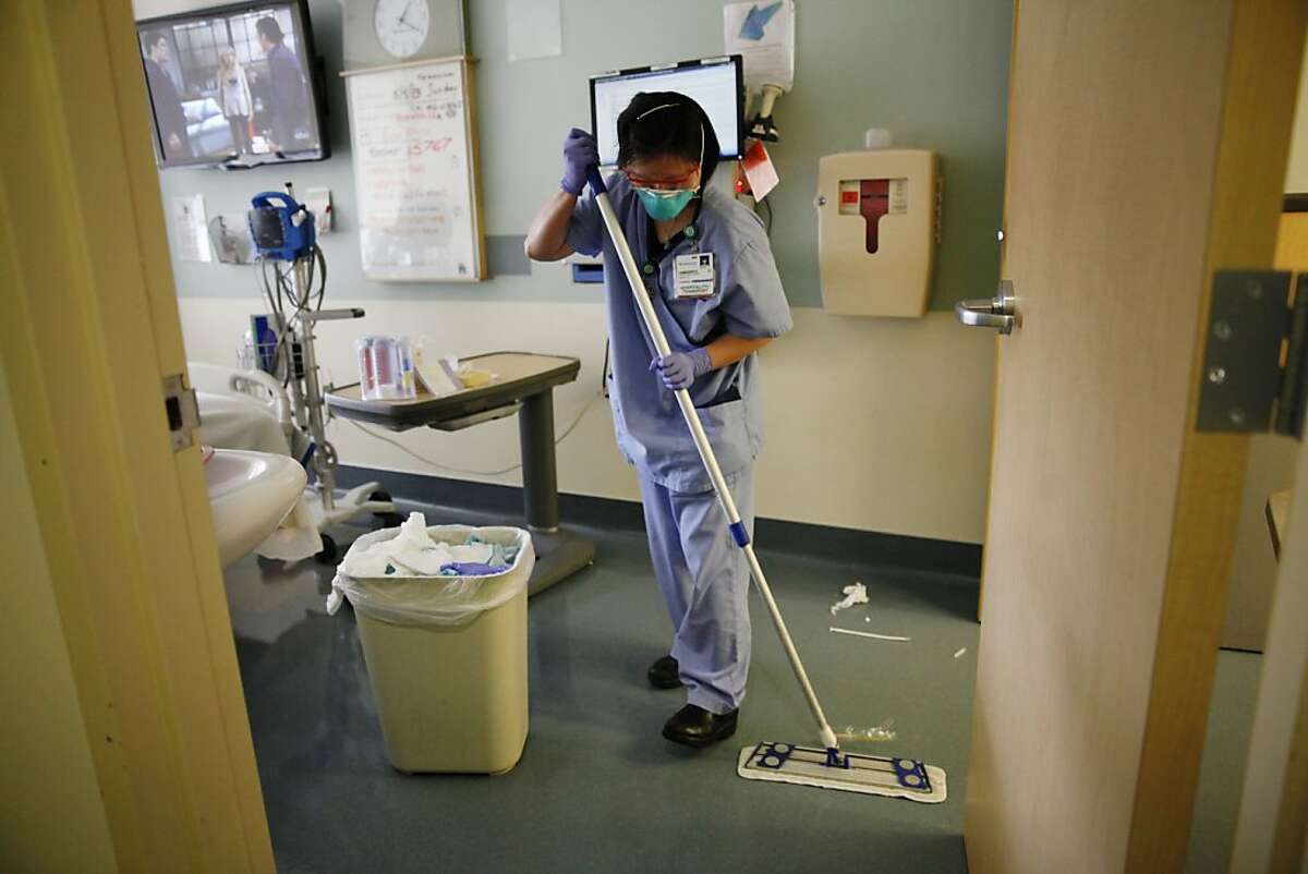 Qianyi Lei, patient support assistant, uses a microfiber mop while cleaning a hospital room at UCSF Long Hospital on Monday, May 6, 2013 in San Francisco, Calif.