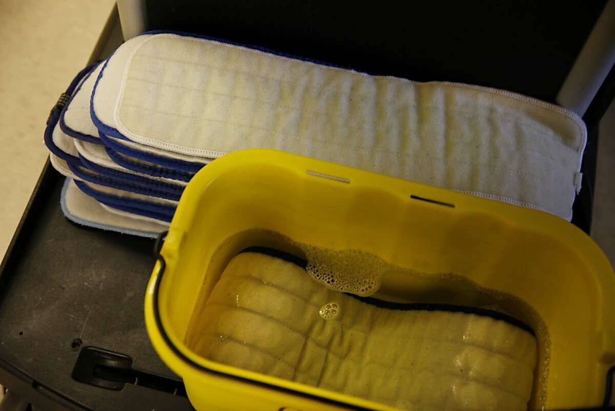A tub is filled with microfiber mop pads soaking in cleaner next to a stack of clean pads at UCSF Hospital on Monday, May 6, 2013 in San Francisco, Calif.