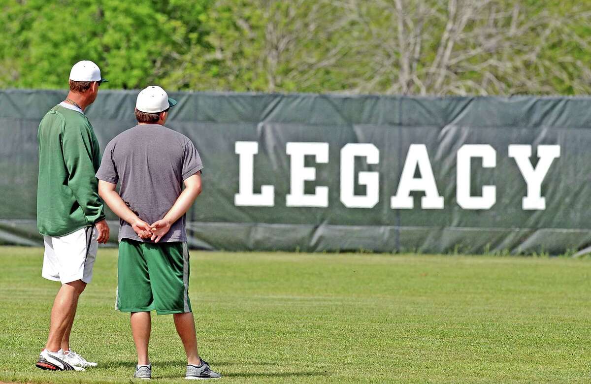 Coach Chris Fackler, left, for the Legacy Christian Academy and assistant coach Kolby Morgan, right, look over the field before practice starts on Thursday, April 25, 2013. Photo taken: Randy Edwards/The Enterprise