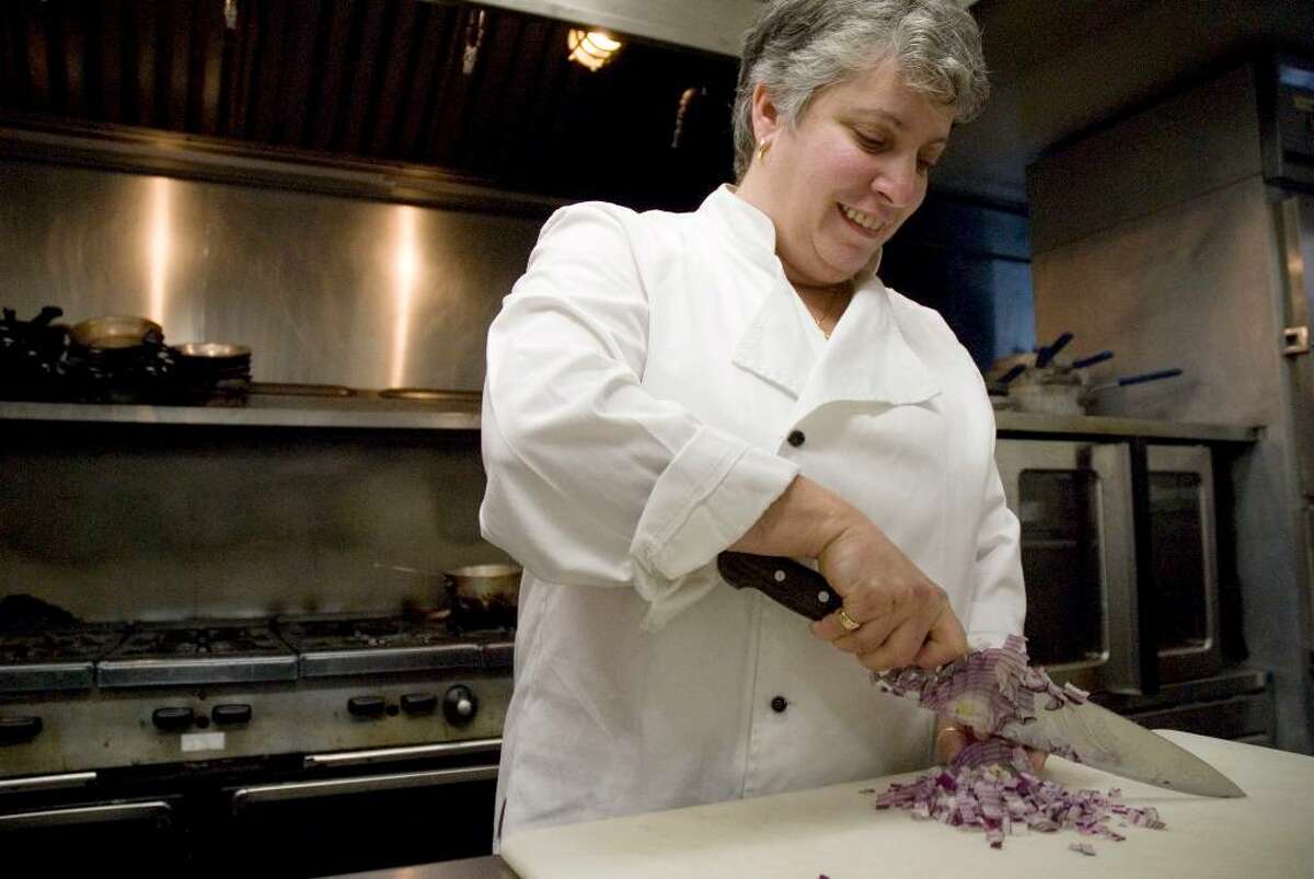 Chef and Owner Adrienne Sussman chops an onion Wednesday in the kitchen at Adrienne Restaurant in New Milford.