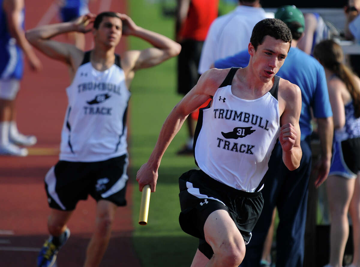 Trumbull's Kevin Crossley takes the baton from teammate Rami Mohamed in the 4X800 relay race, during boys track action against Fairfield Ludlowe and Central in Fairfield, Conn. on Tuesday May 7, 2013.
