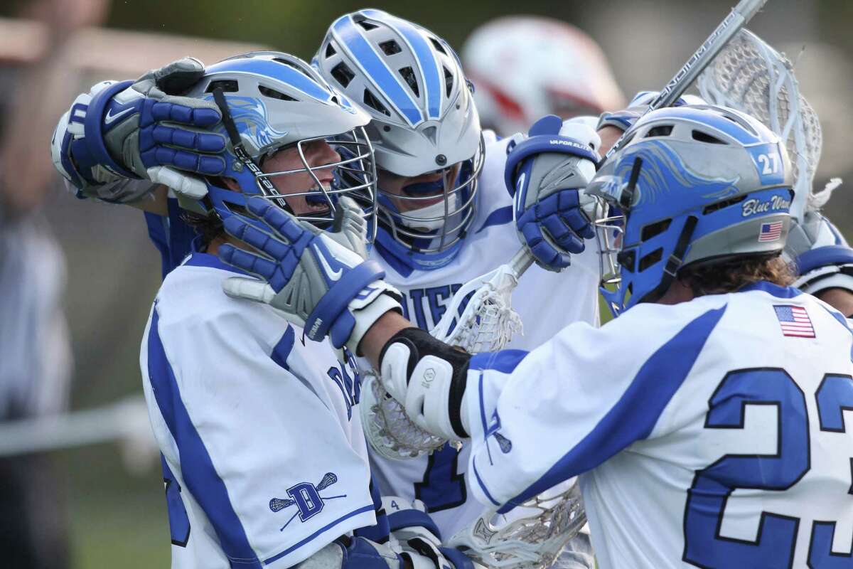 Darien lacrosse plyers Jack Kniffen, John Reed and Kevin Seiler celebrate Kniffen's fourth quarter goal against Ridgefield. Darien won the closely fought game, 9-7. © J. Gregory Raymond for The Advocate