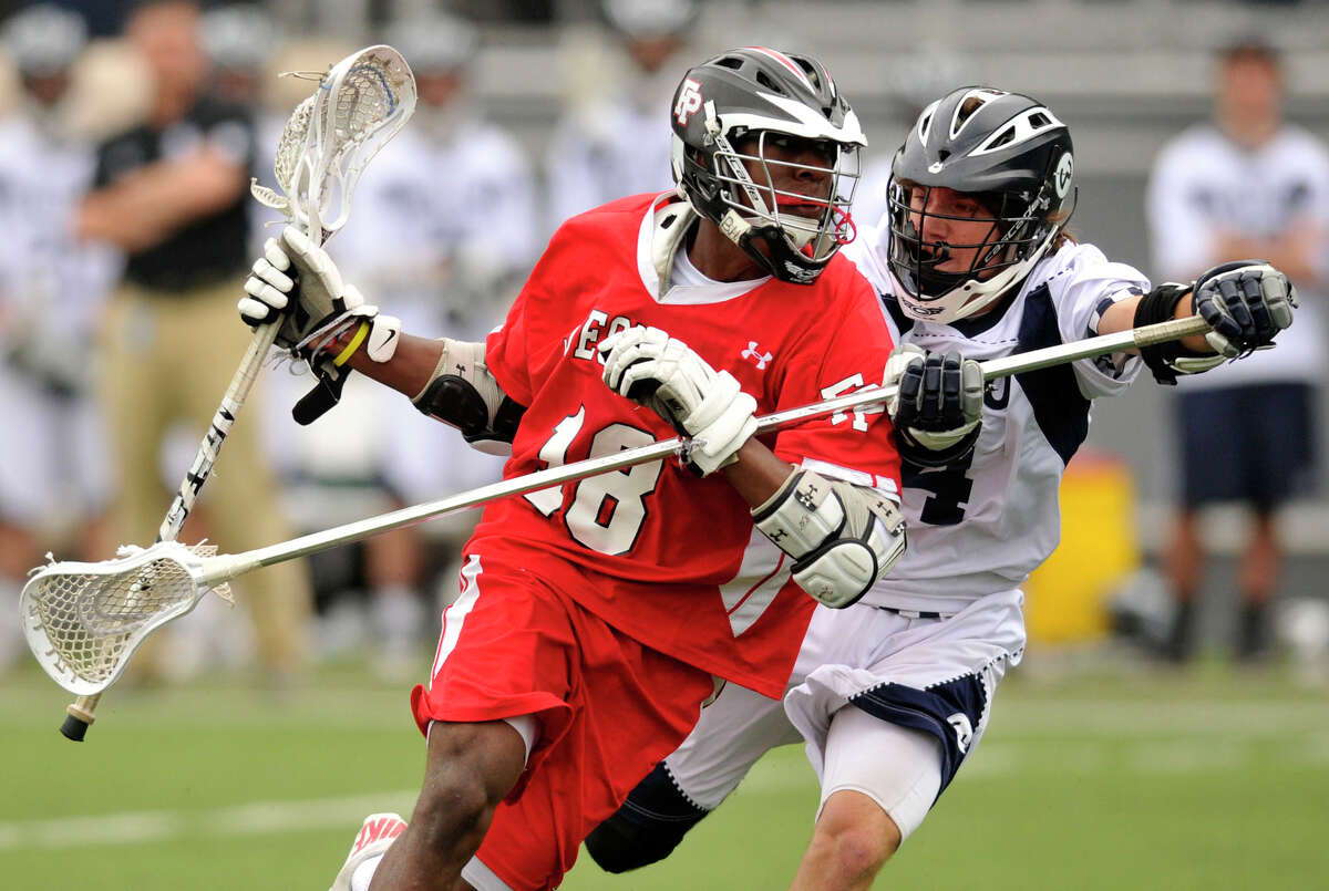 Fairfield Prep's Austin Sims runs down the field while under pressure from Wilton's Henry Lee during their game at Wilton High School on Wednesday, May 8, 2013. Fairfield Prep won, 16-9.