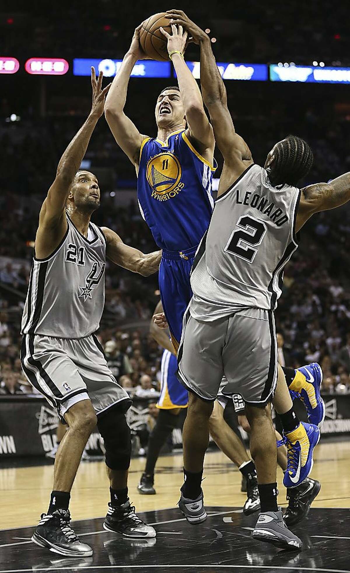 Golden State Warriors' Klay Thompson drives between San Antonio Spurs' Tim Duncan and Kawhi Leonard during the second half of Game 2 in the NBA Western Conference semifinals at the AT&T Center, Wednesday, May 8, 2013. The Warriors won, 100-91 to even the series at 1-1.