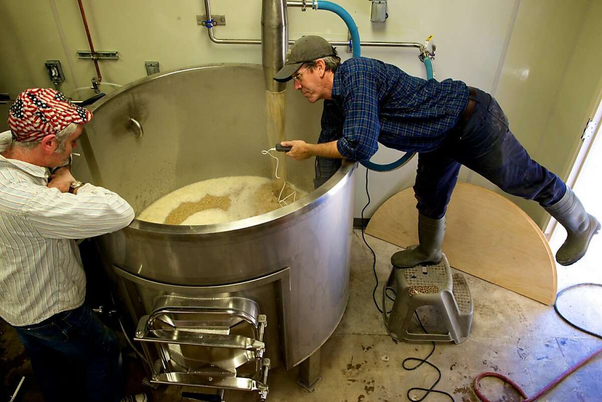 Vincent Johnson of the U.K.'s Johnson Brewing Designs, left, watches at FreeWheel Brewing Co. head brewer Malcolm McGinnis brews a batch.